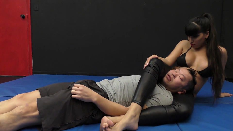 She wrestle him down on the mat and jerks off his cock after leg scissors